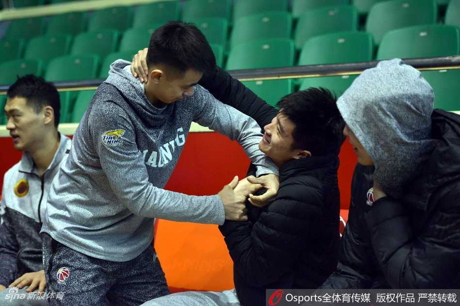 辽宁队大脑赵继伟与山东队球员进行赛前交流，两人神情放松，低头私语，在激烈的比赛前享受这片刻的宁静与兄弟情谊