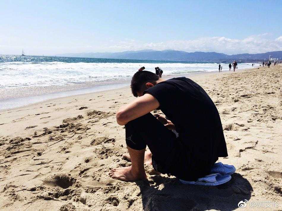 郭艾伦的美国特训日记:沙滩、烤苞米与篮球的快乐交响 阳光洒在郭艾伦的笑脸上,他穿着休闲T恤,在海滩的微风中惬意地啃着金黄喷香的烤苞米,眼神里都是放松。