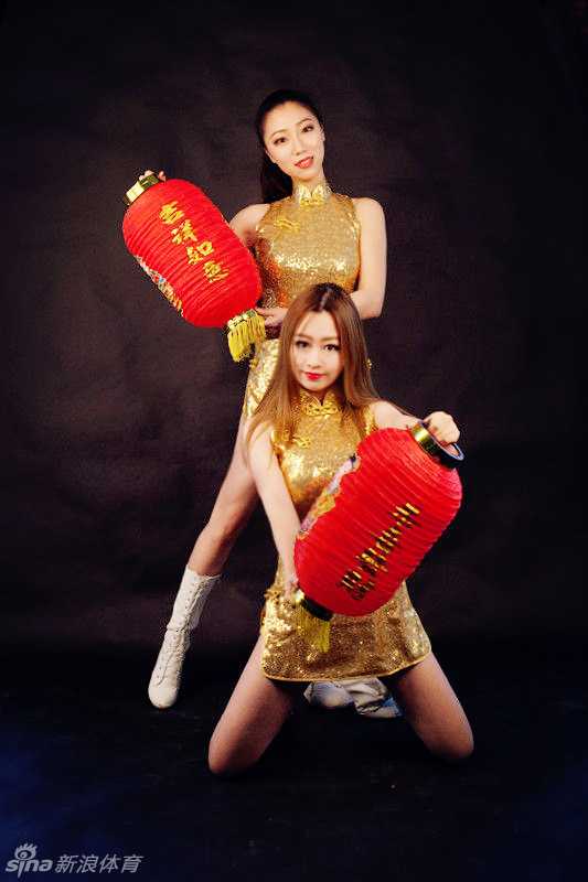 几位宝贝一起对着镜头比出爱心的手势，她们身穿色彩鲜艳的节日盛装，背景是红彤彤的剪纸装饰，将新年的欢乐气氛推向高潮