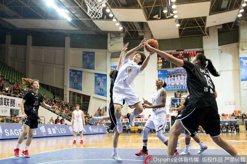 江苏队核心李珊珊运球过半场，她眼神坚定地看向前场，同时伸出三根手指比划战术手势，身旁的广东队防守球员寸步不离，紧贴着她，场上气氛紧张到了极点。