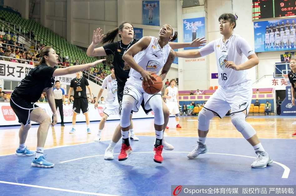 广东队外援约翰逊在三人包夹下强行上篮，她肌肉紧绷，表情坚毅，篮球在空中划过一道弧线，防守球员的手掌几乎封到了她的脸上，展现出极强的个人能力和对抗中的冷静。