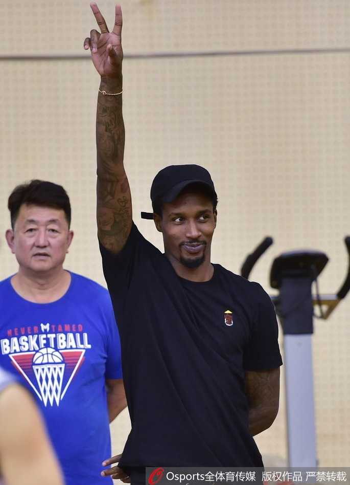 活动尾声，山西男篮全队与太原五中师生代表合影留念，斯科拉站在后排中央，一手拿着互赠的礼物，标志性的笑容定格在这一温暖的公益瞬间。