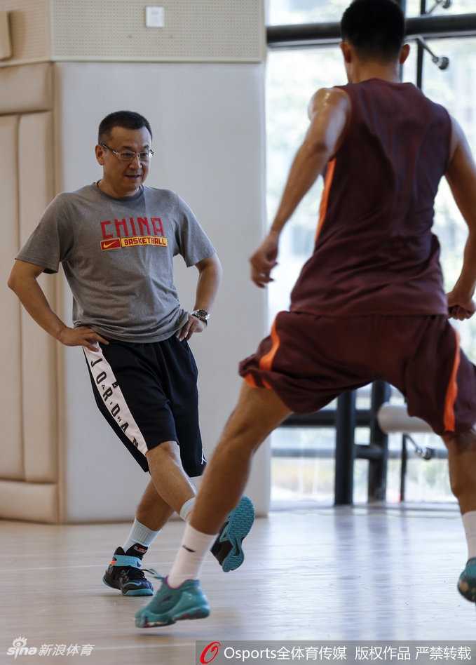 范斌摘下眼镜仔细擦拭，目光却依然没有离开场上的训练，每一个细节的调整都体现着他对于执教工作的全情投入。