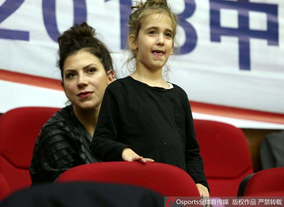 铁汉柔情:希腊中锋博洛西斯的篮球征途与场边最暖注视 比赛暂停间隙,博洛西斯坐在替补席休息,他的小女儿在球迷区天真烂漫地玩耍,与紧张激烈的赛场氛围形成温馨对比。