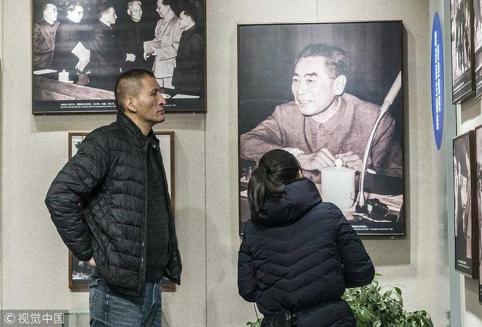 铁血篮臣仰高风:巴特尔静思周恩来纪念馆 巴特尔与友人一同观看纪念馆内的历史照片,高大的背影在展板前显得格外专注,透着对历史的敬畏