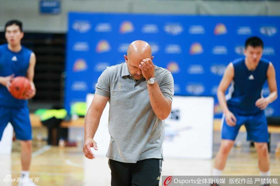 希腊主帅雅尼斯站在场边陷入沉思，面对全新的球队阵容，他习惯性地挠着头，眼神中透露出对训练细节的严格考量与战术布置的深思熟虑。