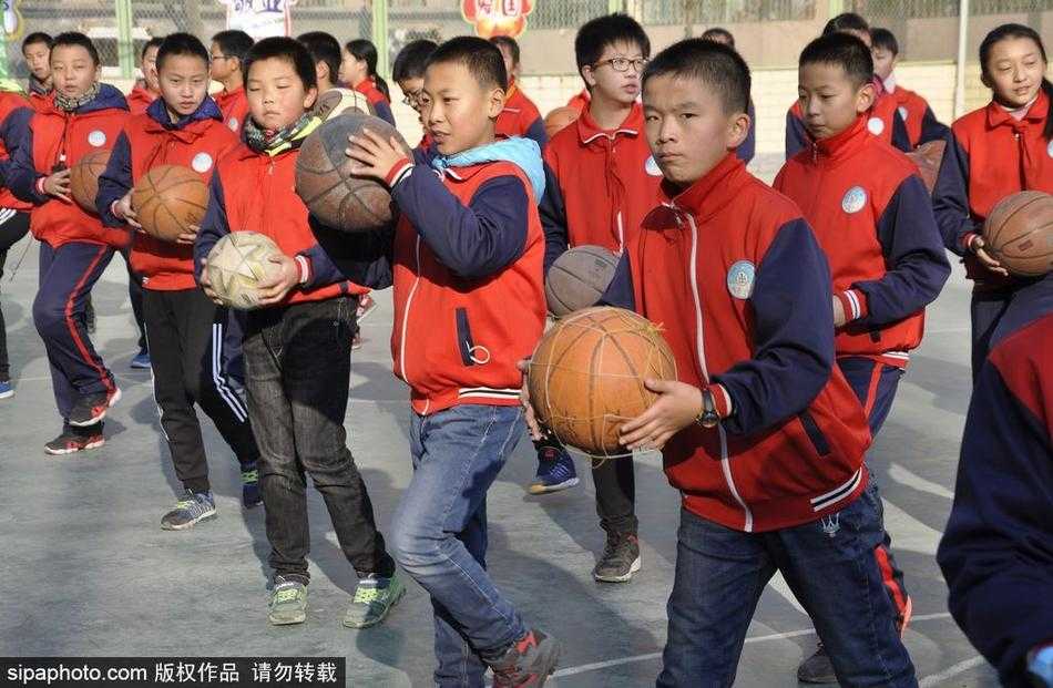 雪域高原上的篮球梦想:西宁水井巷小学千名学子演绎活力篮球操 空中俯瞰的视角下,数百名学生在操场上摆开阵势,他们手中的篮球同时腾空,又同时落下,整齐得如同一个人。整个操场被巨大的节奏感所笼罩,展现出团队协作的极致之美。