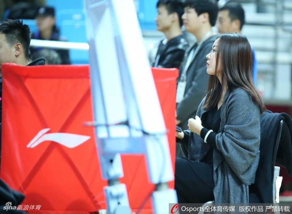 这位女球迷在人群中微微一笑，温婉动人，仿佛周遭的喧嚣都与她无关，只有场上的动静牵动她的心