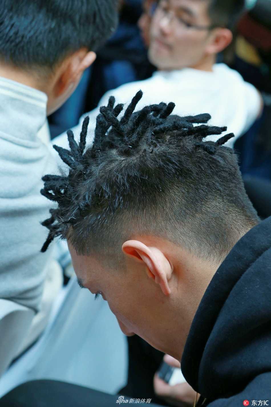 阿不都沙拉木与俞长栋并肩而坐，耐心倾听球迷的提问，背景中隐约可见‘新疆劳道’的标语，诉说着这片土地对篮球最纯粹的爱。