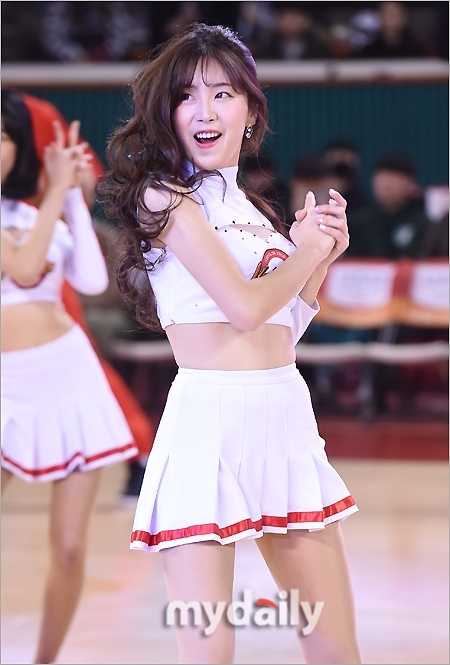 比賽結束的哨聲吹響，啦啦隊員們仍留在場內向觀眾致意。她身著閃亮的舞台裝，臉上掛著真摯的笑容，高舉雙手比出愛心手勢，為這個激情夜晚畫下圓滿句點。