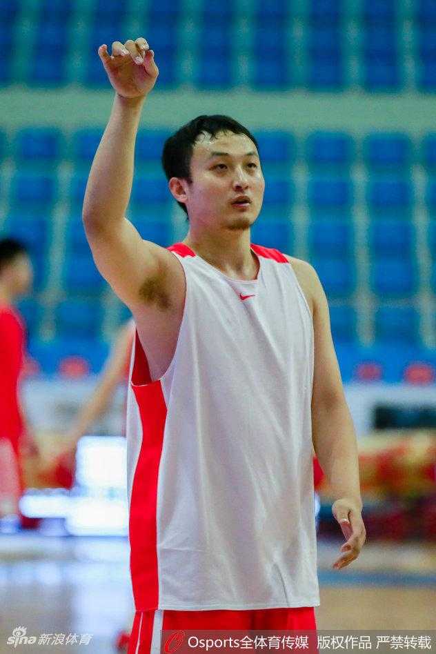 山东全运男篮全队训练场景，丁彦雨航站在队伍中与队友交流战术，他的新发型在人群中格外显眼，整体氛围团结而专注。