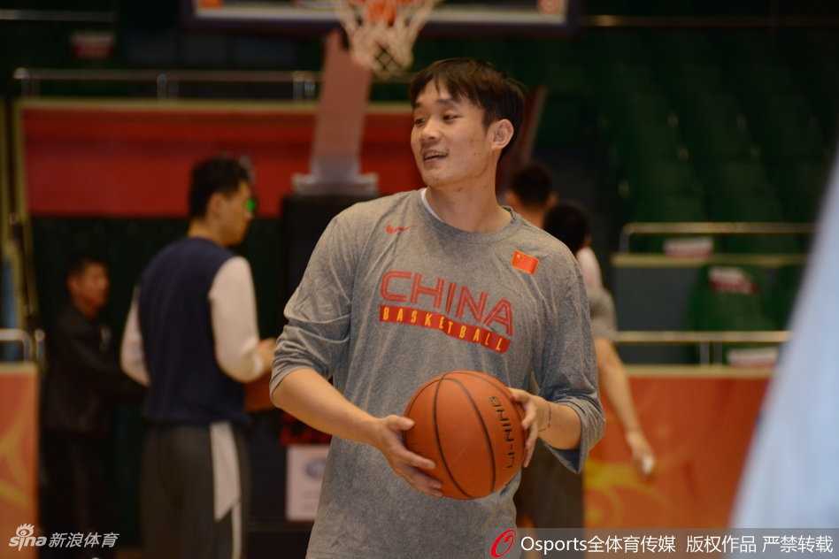 一位年轻队员在训练中高高跃起，试图封盖队友的投篮，阳光透过窗棂洒在他坚毅的面庞上，青春的力量在此刻尽情绽放。