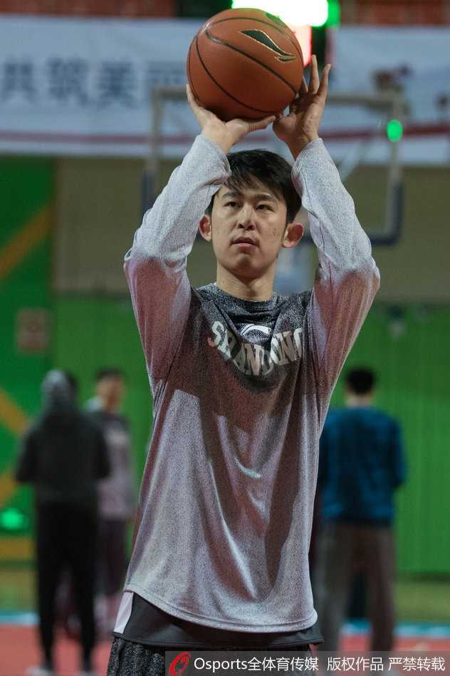 训练结束后，丁彦雨航加练投篮，汗水湿透了训练服，但他依旧专注地出手，身后的巨大海报仿佛映衬出他扛起山东队前行的坚定背影。