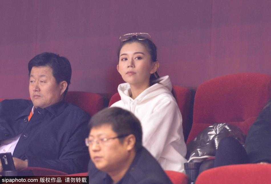 一位为青岛队加油的美女球迷，她的神情专注而略带紧张，在这场齐鲁德比中，她与场上球员同呼吸共命运。