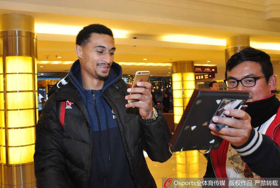 球员通道内，广东队工作人员正忙碌地搬运着沉重的装备箱，背景是灯光璀璨的球馆入口，预示着大战一触即发，每个细节都透着紧张与秩序。