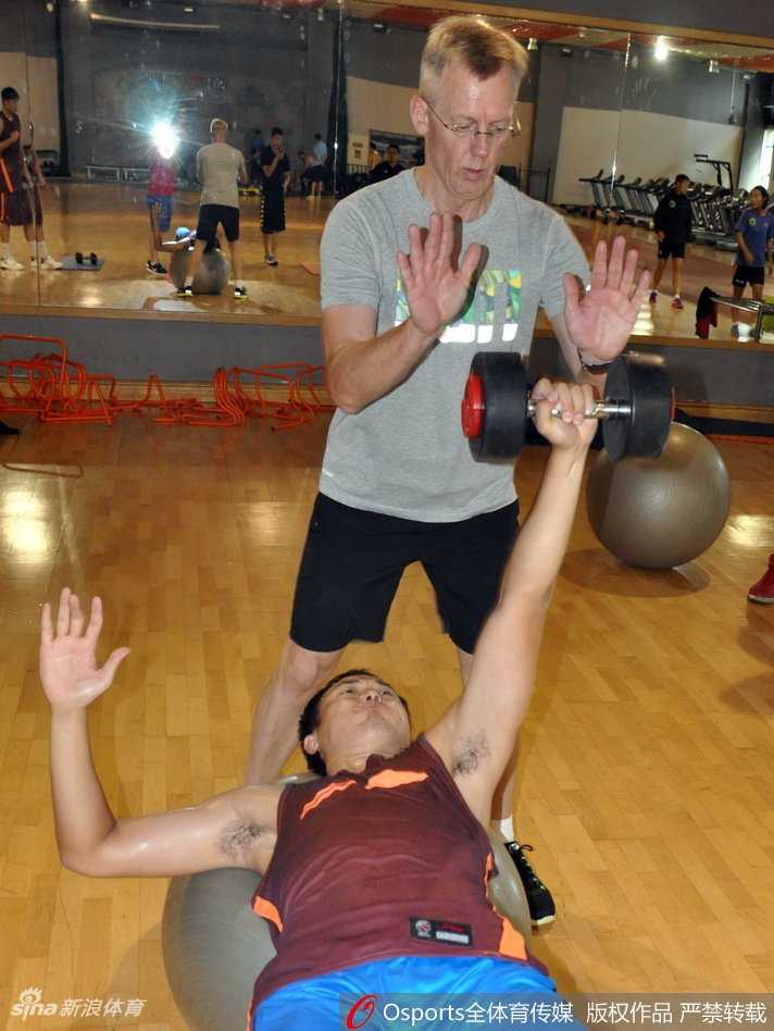 吴轲双手紧握器械把手，身体后仰，全身肌肉紧绷，正在进行高强度的背部肌肉训练