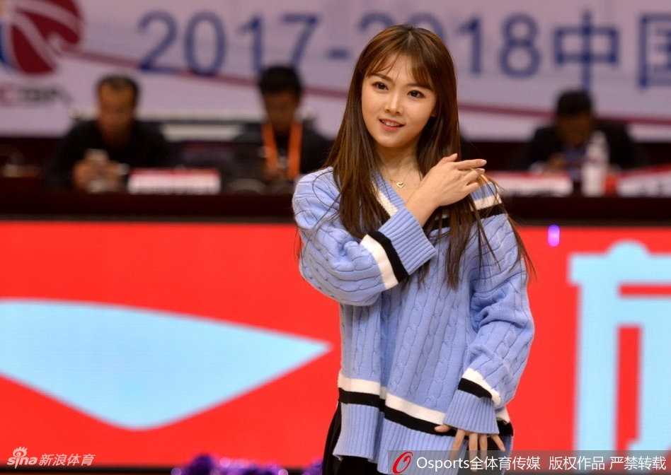 一位眼神专注的啦啦队员在场边候场，妆容精致，静待上场指令