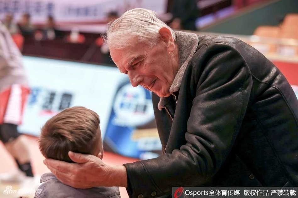 金发碧眼的稚童挥舞着山东队的小毛巾，眼神懵懂却专注地盯着场内，仿佛能听懂篮球撞击地板的战鼓声。